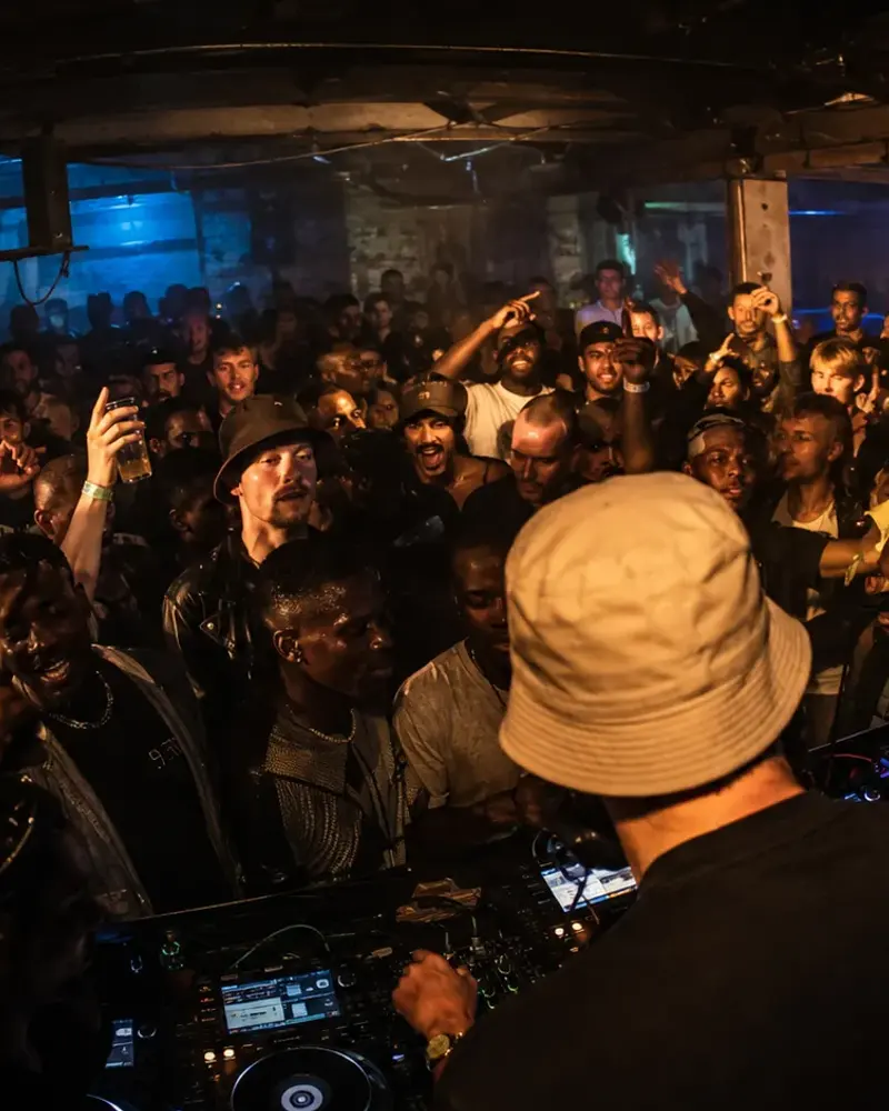 An MC performing over a moving basement crowd.