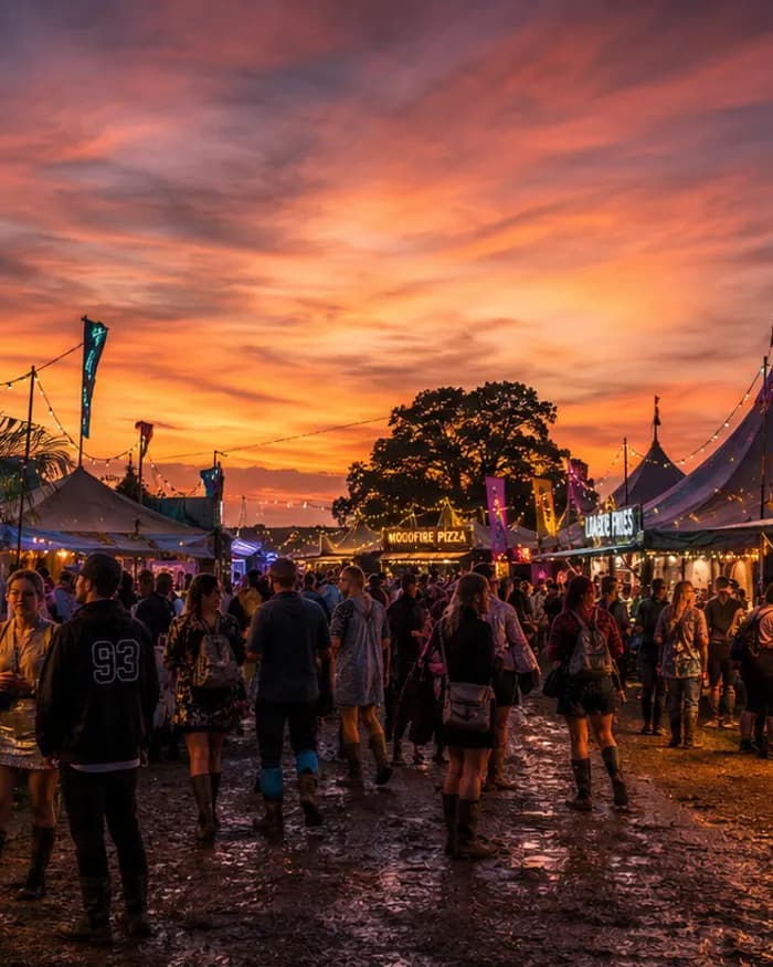 A festival food street at night under a dramatic sky, cocktail and dessert stalls glowing.